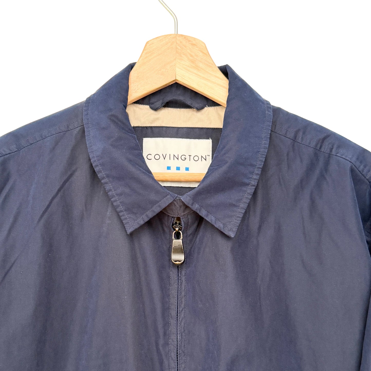 Navy jacket on a hanger with 'Covington' label