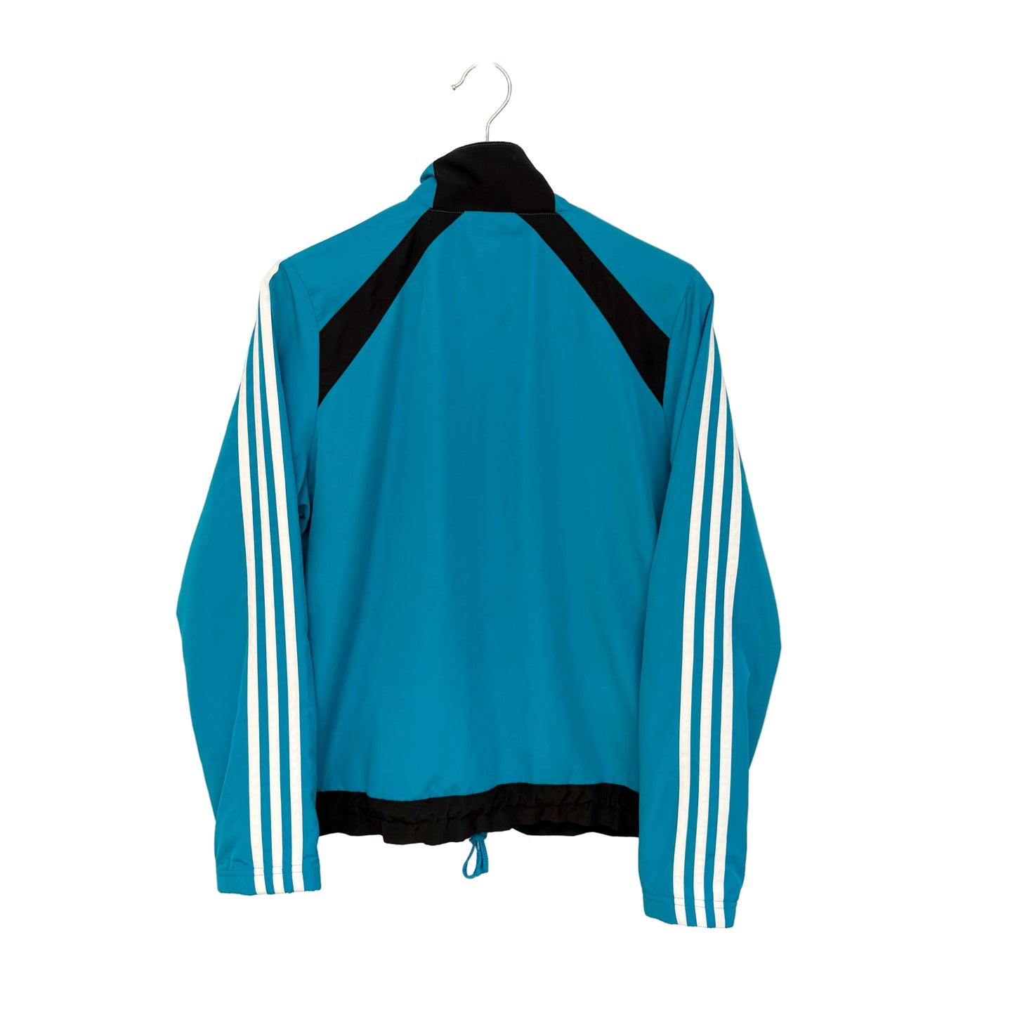 A teal blue track jacket with black shoulder panels, a black collar and hem, and white three-stripes on the sleeves, hanging on a white hanger against a plain off-white wall.