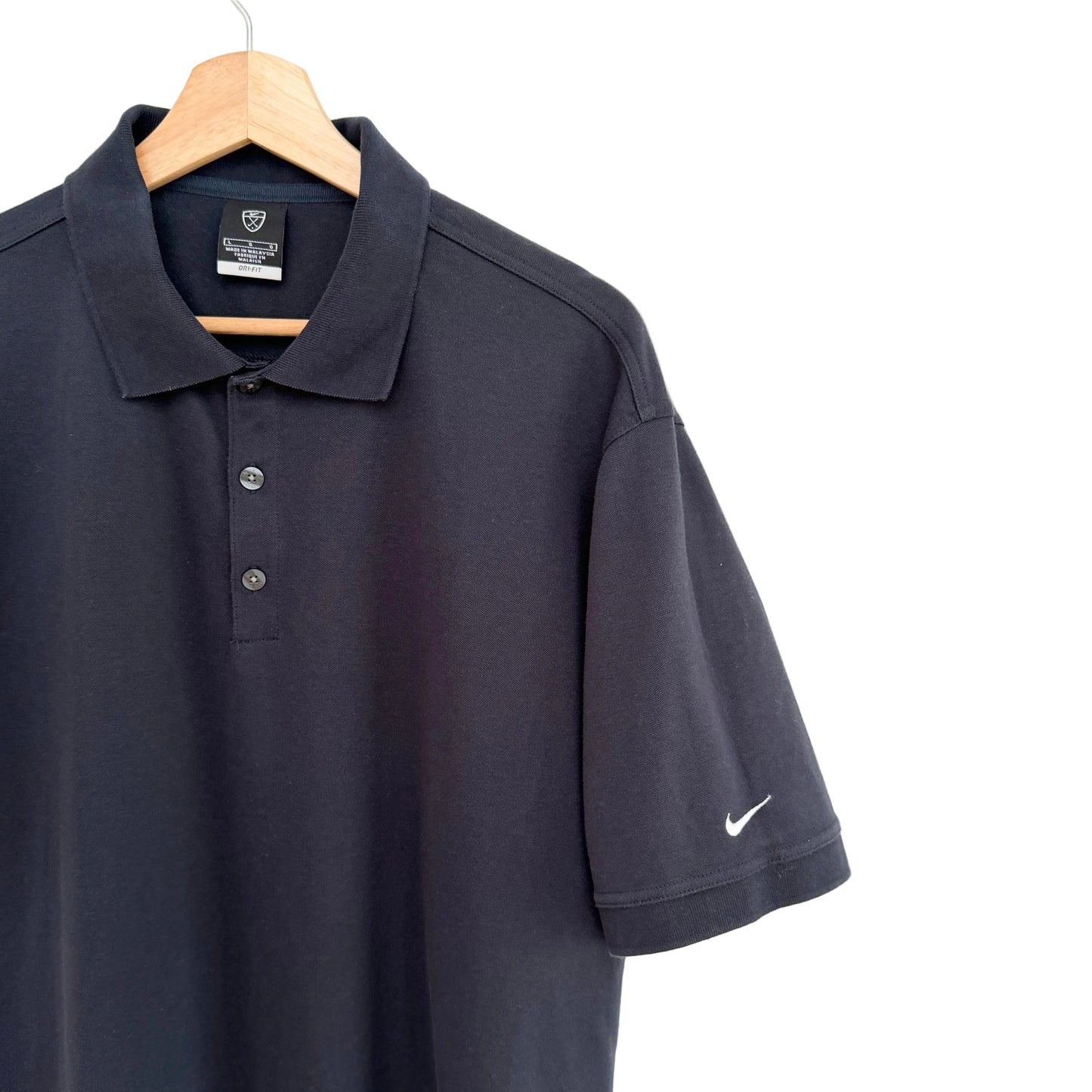 Navy blue polo shirt with Nike logo on a hanger against a white background