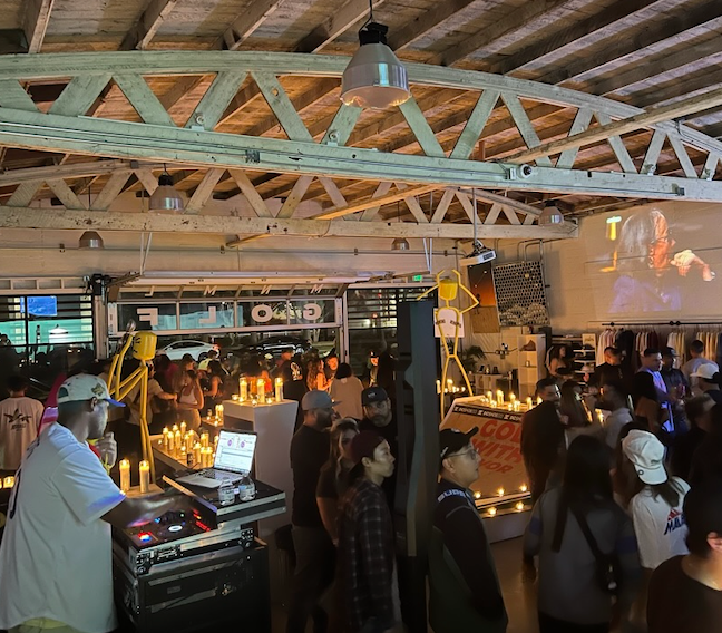 This is a picture of MNML GOLF Club and event space during a golf event with space for a dj and a projector.