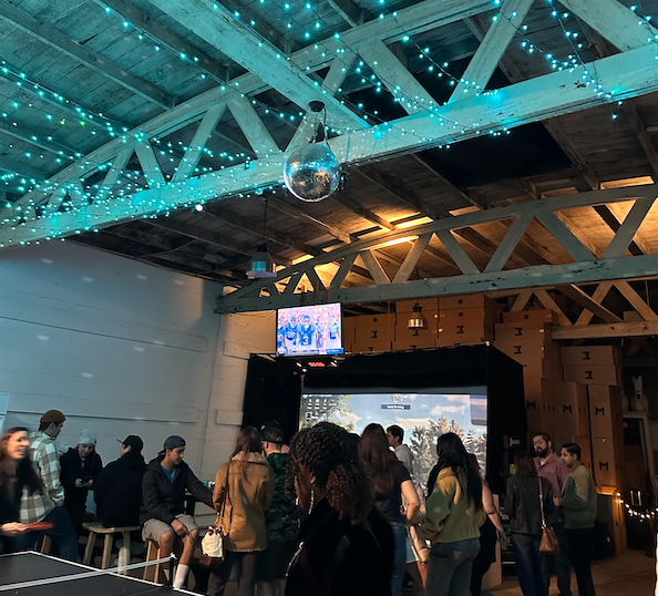 This is a photo of MNML GOLF Club's event space, including two indoor golf simulators.