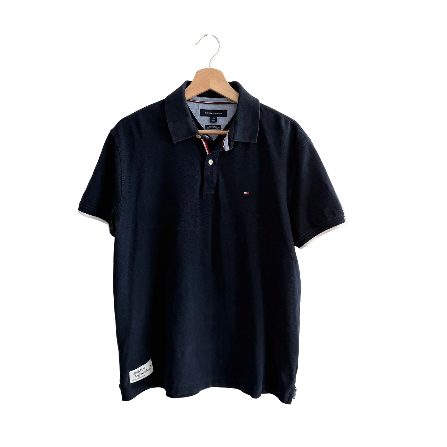 Navy blue polo shirt on a hanger against a white background