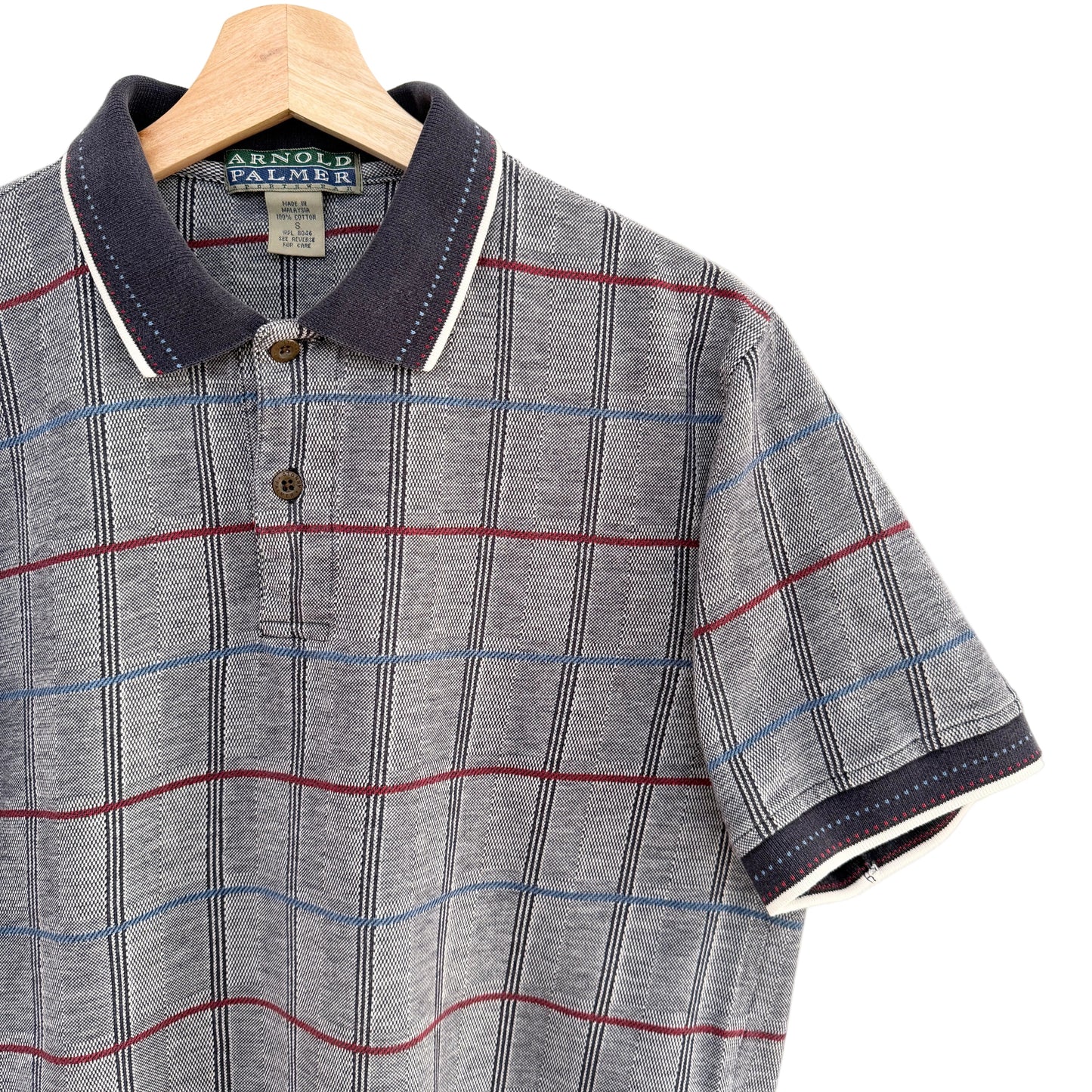 Plaid polo shirt on a hanger with a visible brand label.