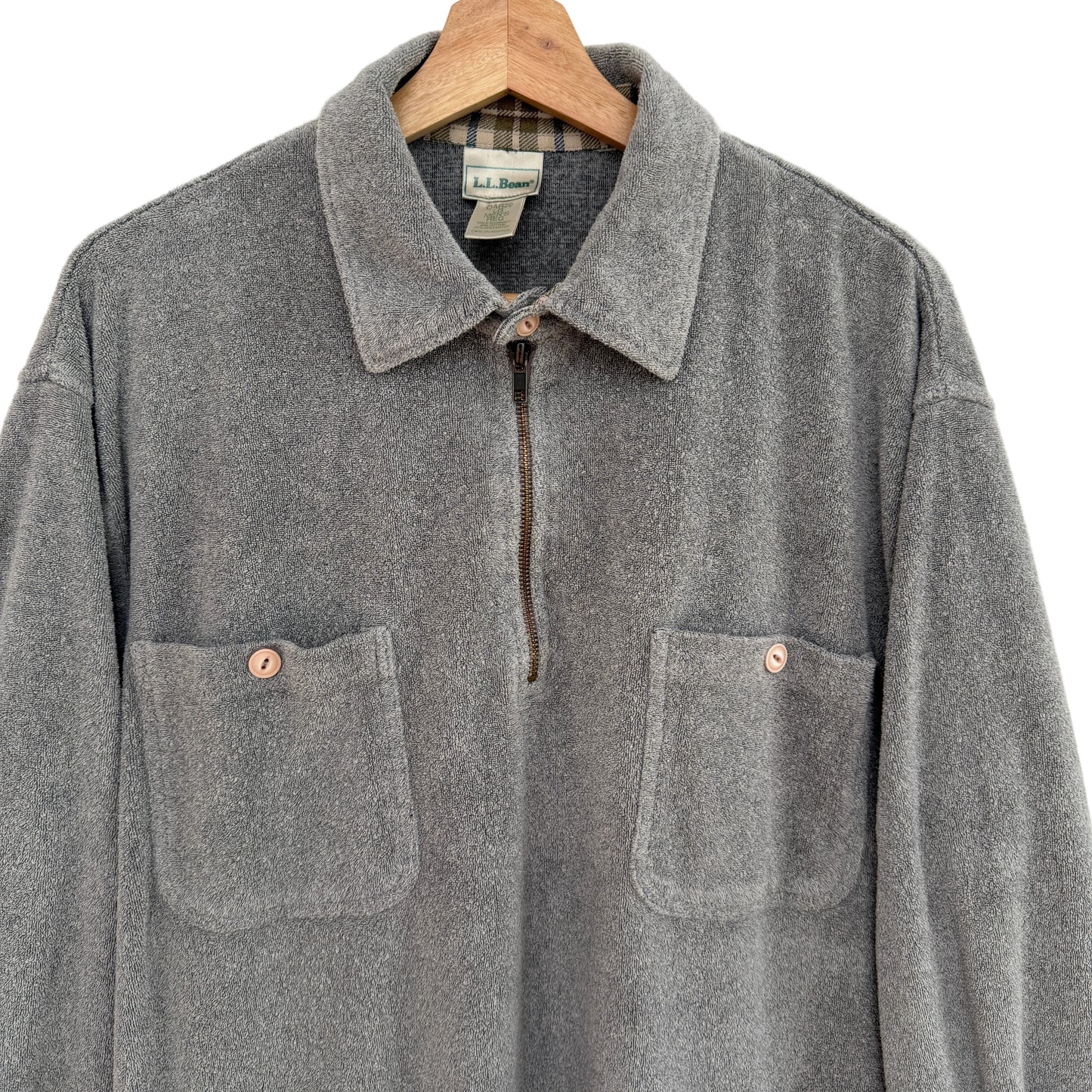 Gray terry shirt on a wooden hanger against a white background