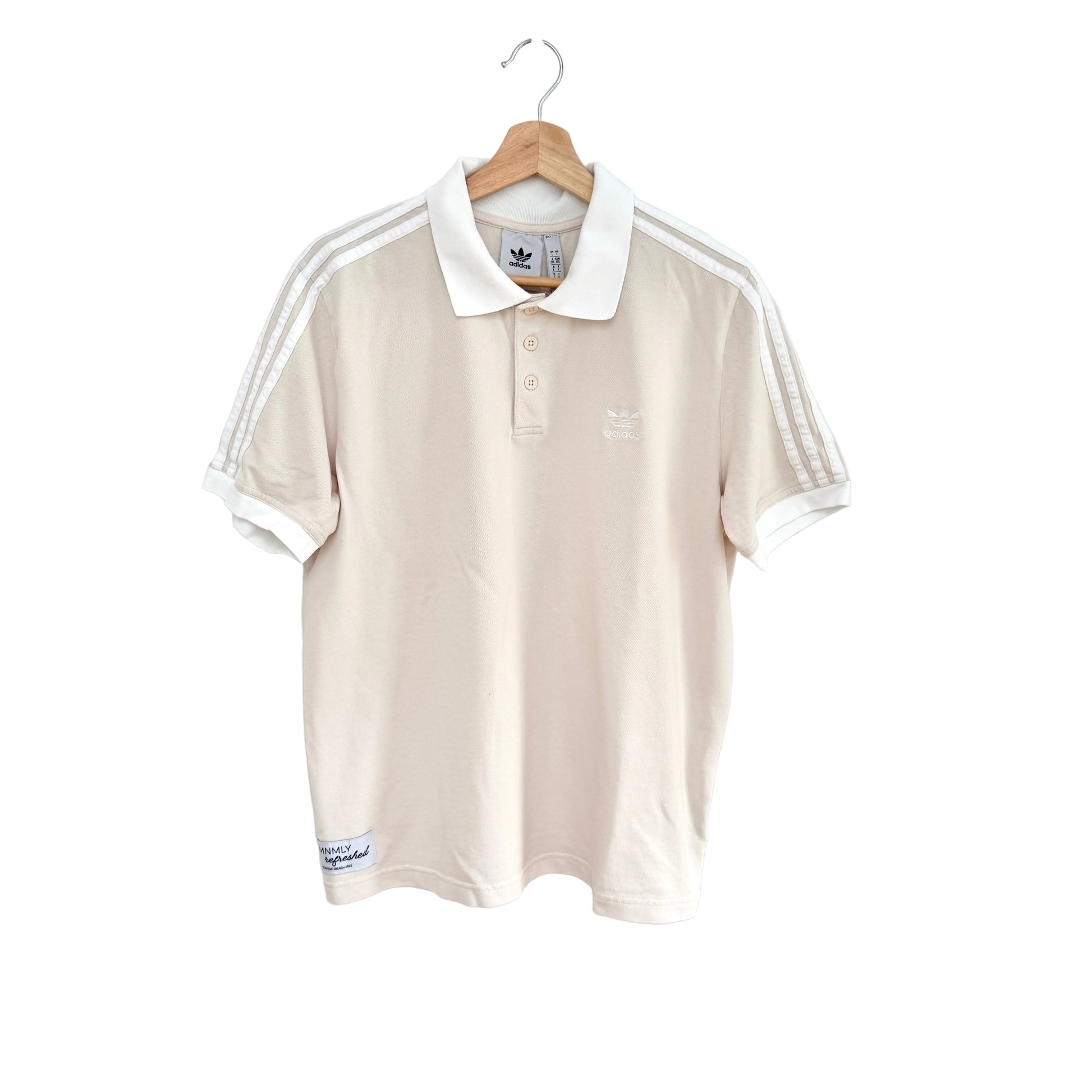 Beige polo shirt with white stripes on a hanger against a white background