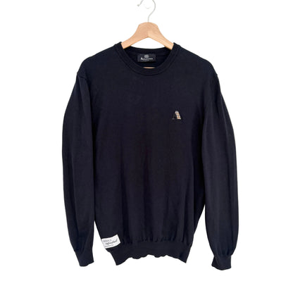 Navy sweater with a small logo on a hanger against a white background