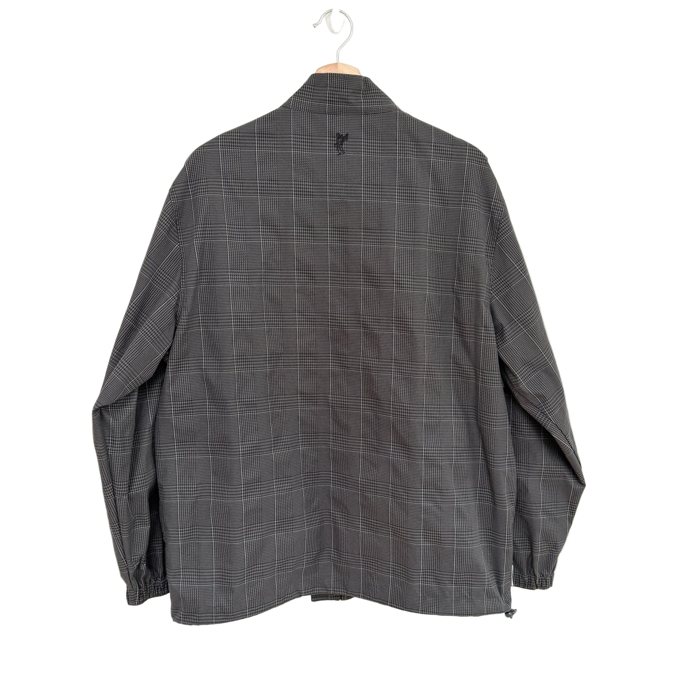 Gray checkered shirt on a hanger against a white background