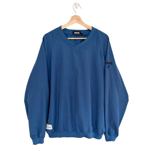 Blue golf windbreaker on a hanger against a white background