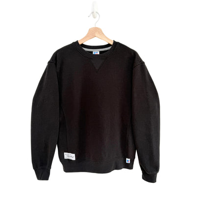 Black sweatshirt on a hanger against a white background