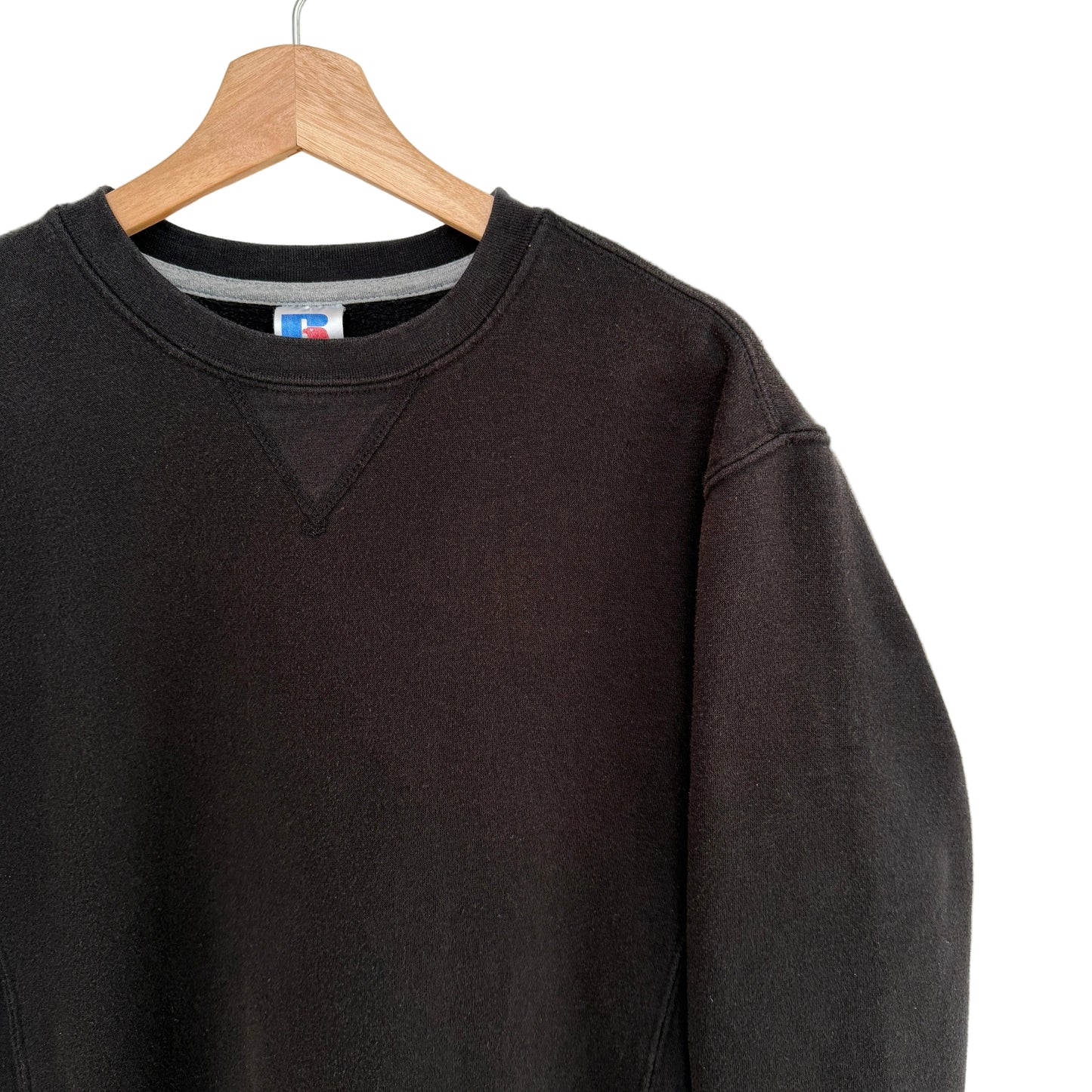 Black sweatshirt on a hanger with a white background