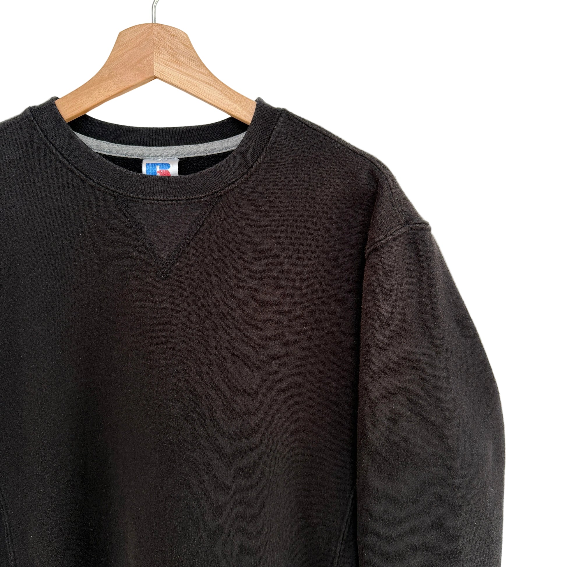 Black sweatshirt on a hanger with a white background