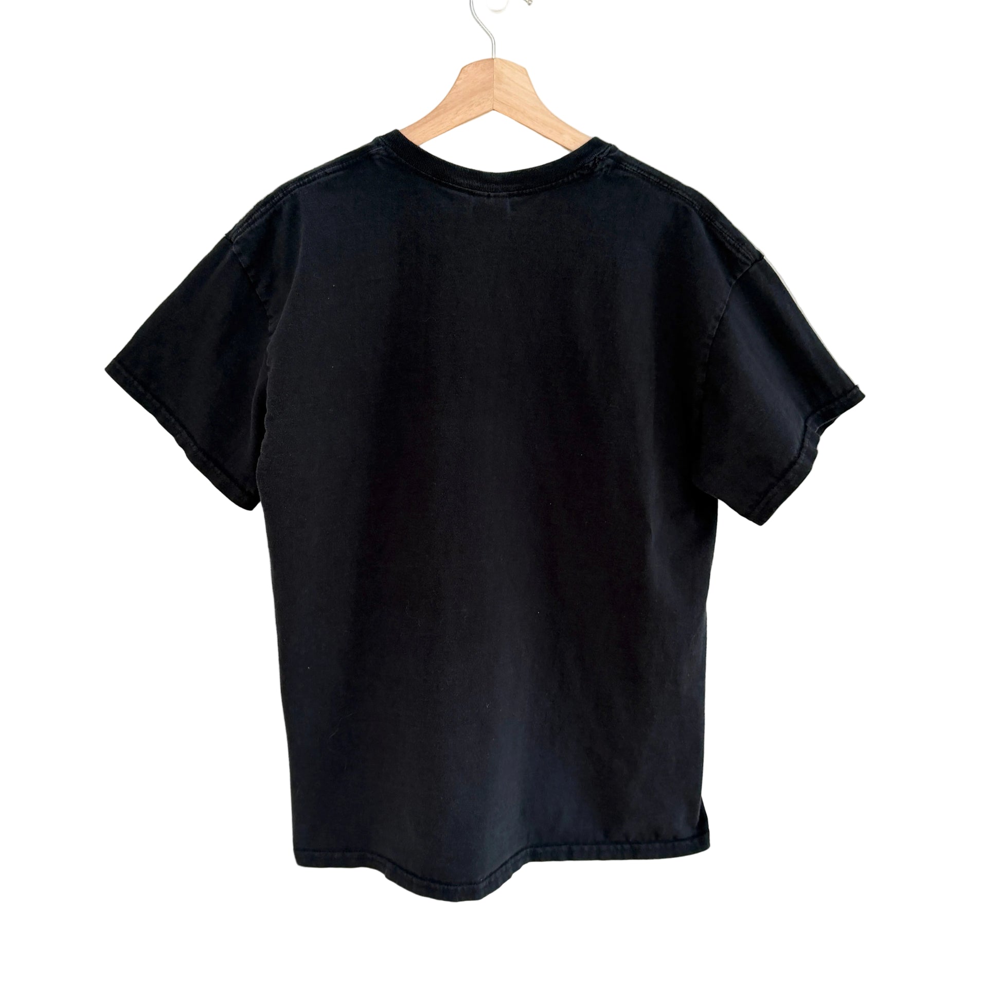Black t-shirt on a wooden hanger against a white background