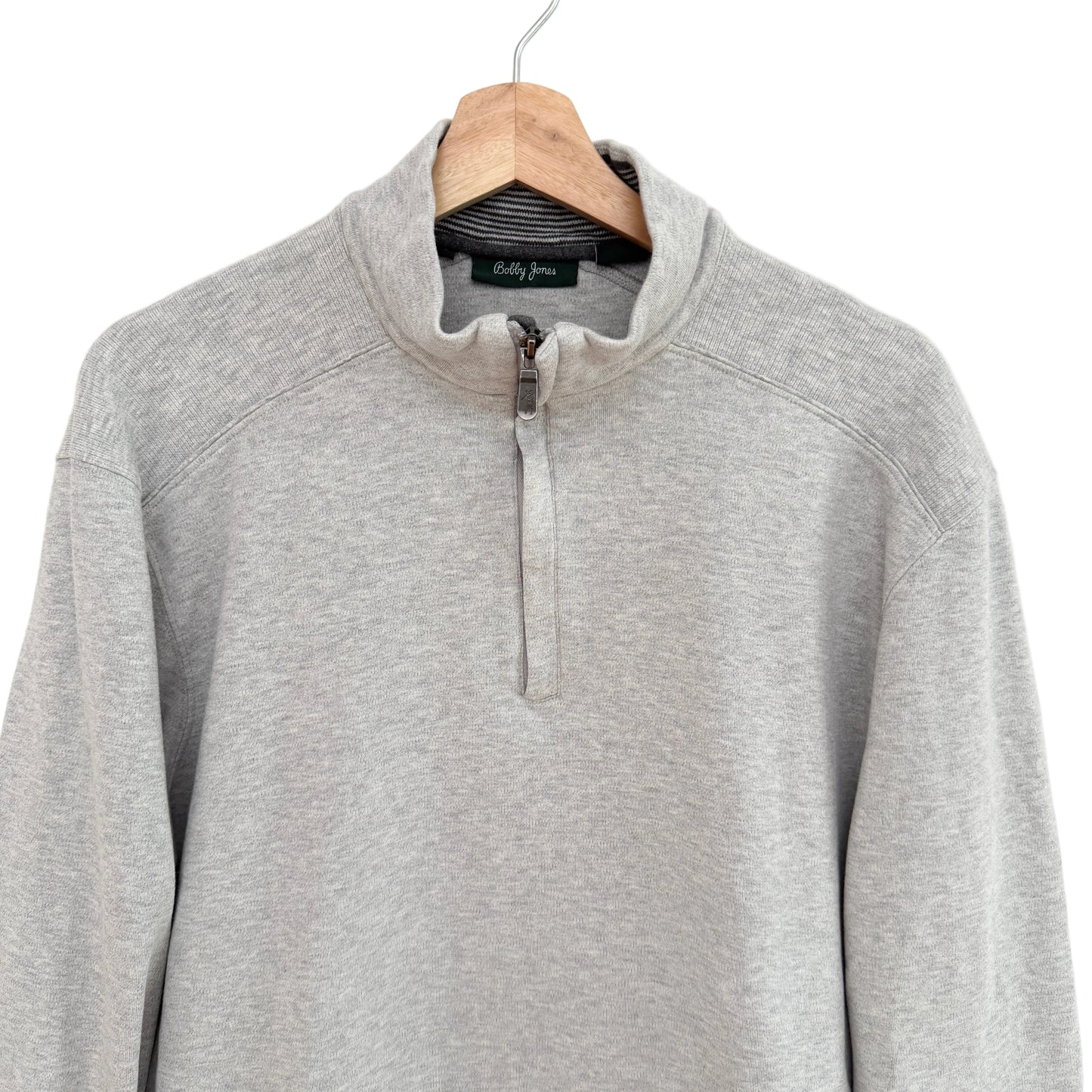 Gray pullover with a quarter zip on a hanger against a white background