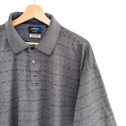 Gray polo shirt on a hanger with a white background