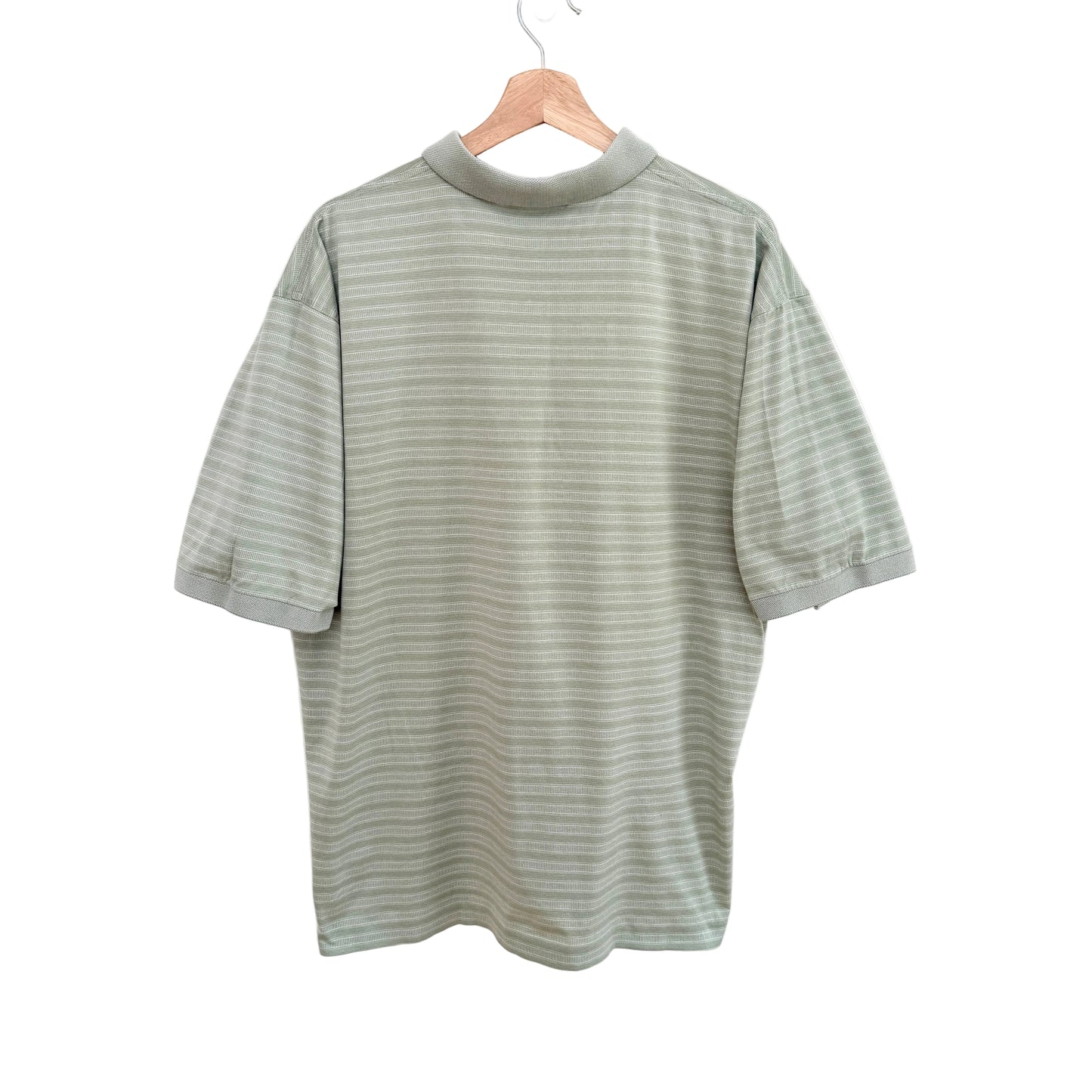 Green striped shirt on a hanger against a white background