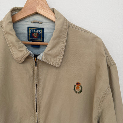 Beige jacket with a logo on a hanger against a white background