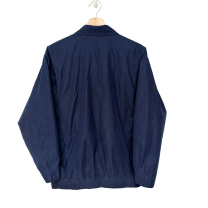 Navy blue jacket on a hanger against a white background