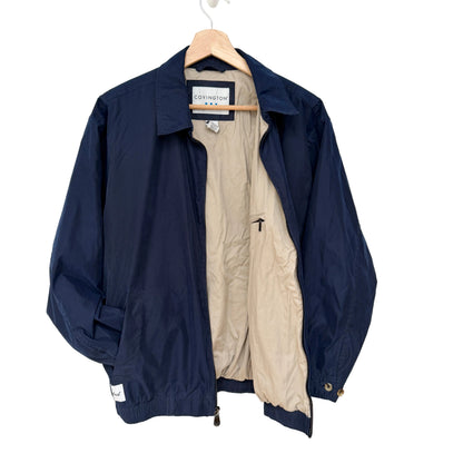 Navy jacket with beige lining on a hanger against a white background
