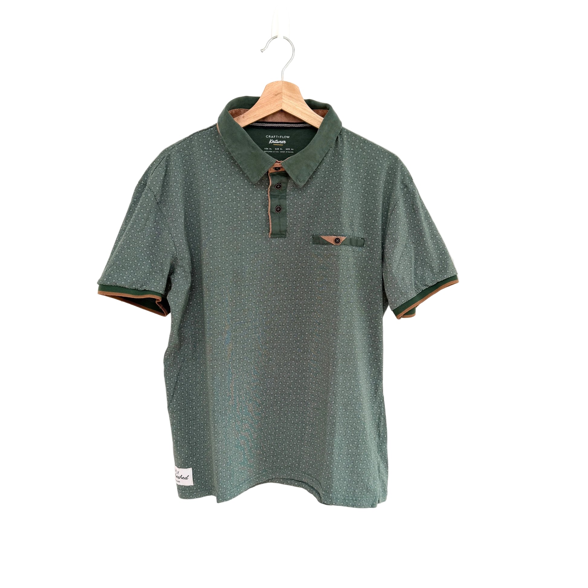 Green polo shirt on a hanger against a white background