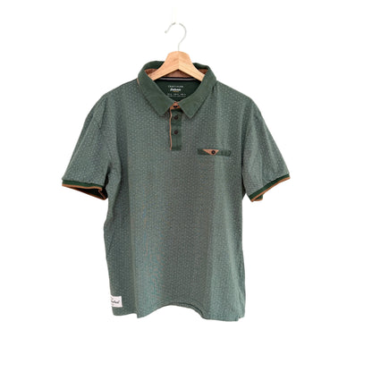 Green polo shirt on a hanger against a white background