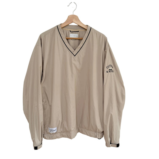 Beige jacket with black trim on a hanger against a white background