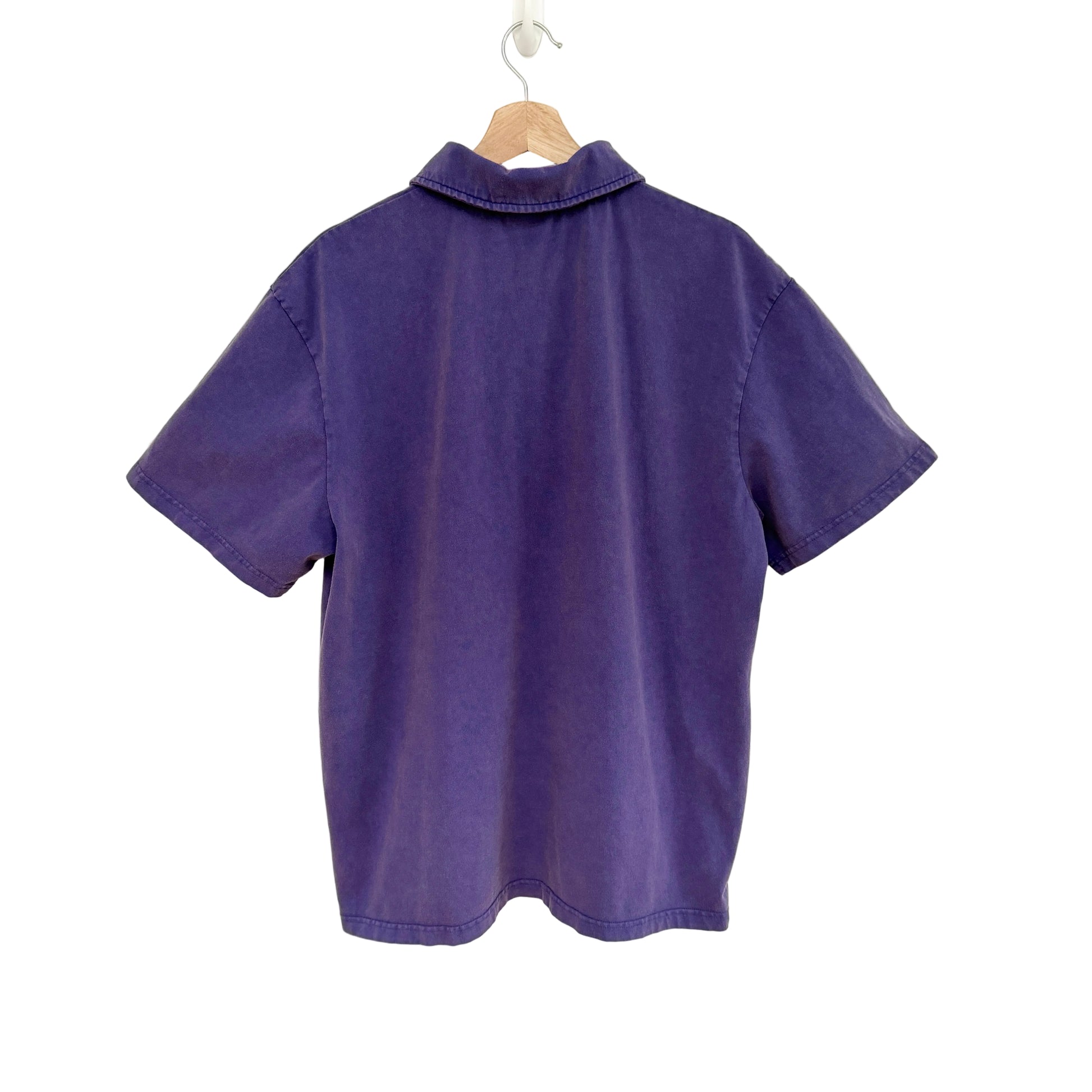 Purple shirt on a hanger against a white background