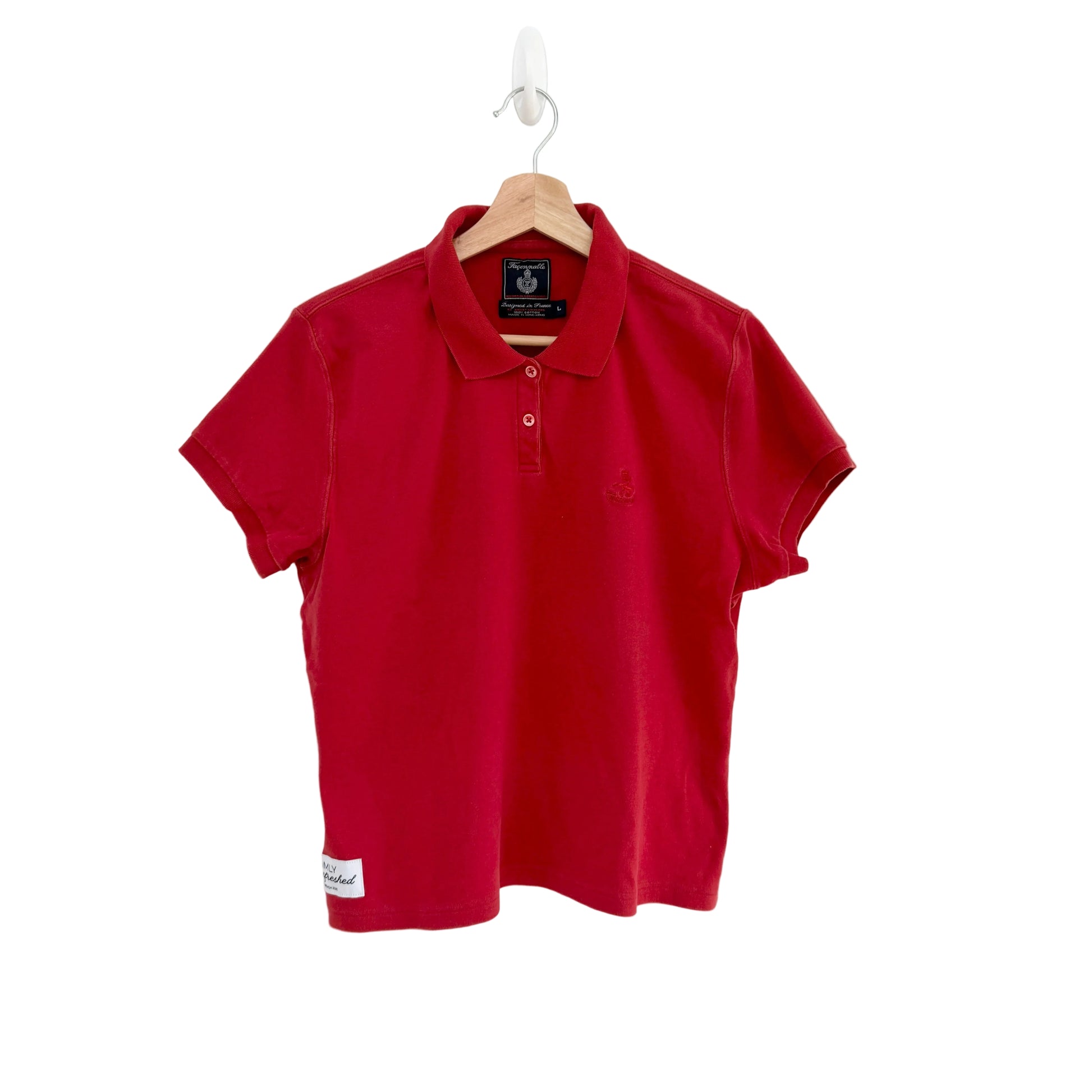Red polo shirt on a hanger against a white background