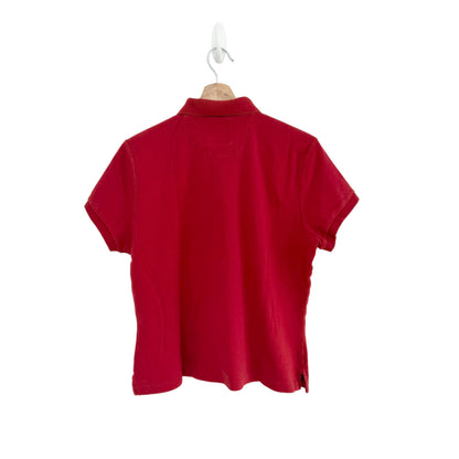 Red polo shirt on a hanger against a white background