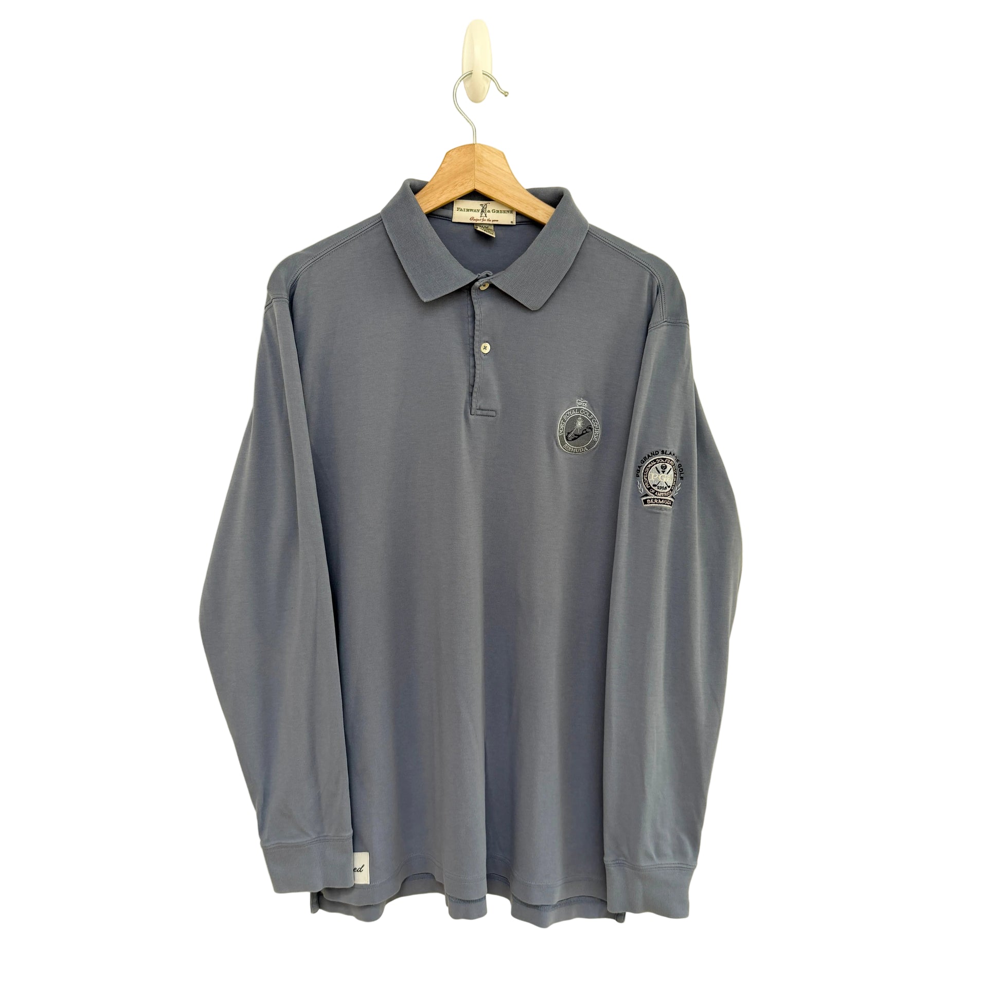 Slate blue long-sleeve polo shirt with logos on a beige background
