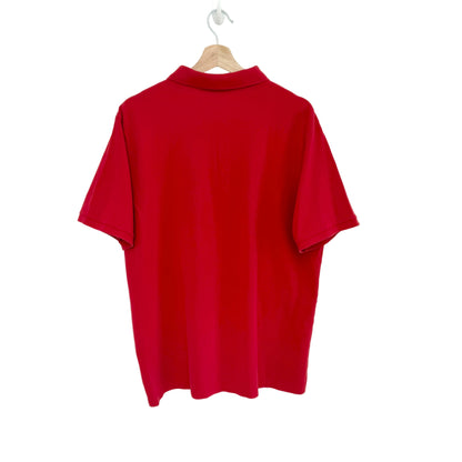 Red polo shirt on a hanger against a white background