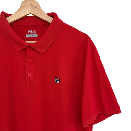 Red polo shirt with Fila logo on a hanger against a white background