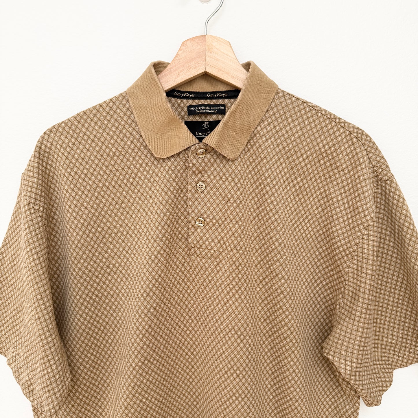 Beige checkered shirt on a hanger with a white background