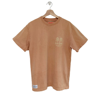 Peach t-shirt with a palm tree design on a hanger against a white background