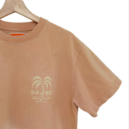 Peach t-shirt with palm tree design on a hanger against a white background