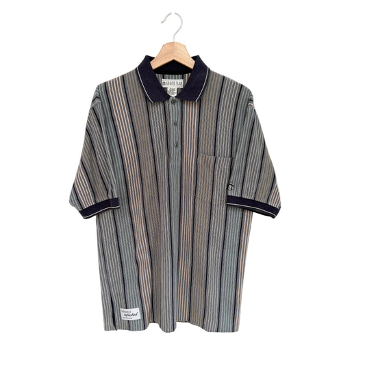 Striped shirt with navy trim on a hanger against a white background