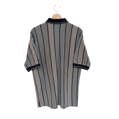 Striped shirt with navy trim on a hanger against a white background