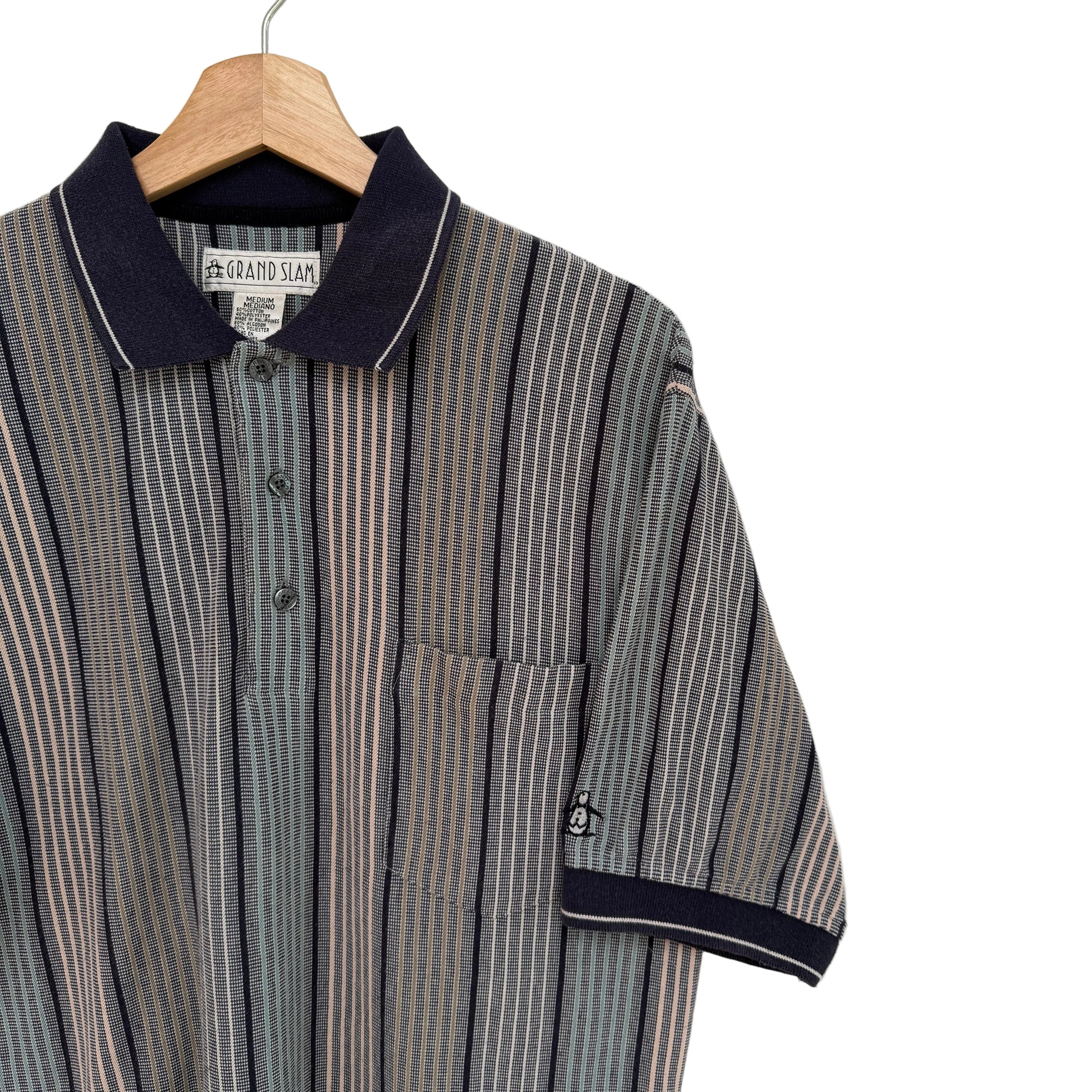 Striped shirt with navy collar and trim on a hanger against a white background