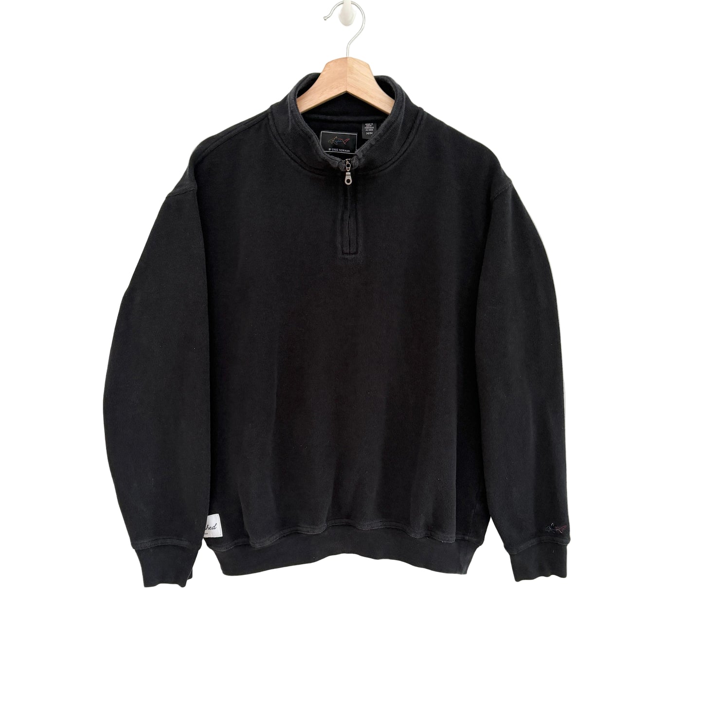 Black sweatshirt on a hanger against a white background