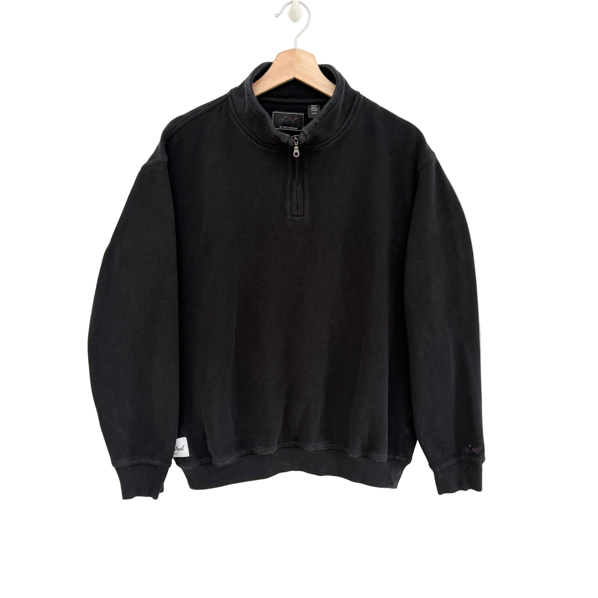 Black sweatshirt on a hanger against a white background