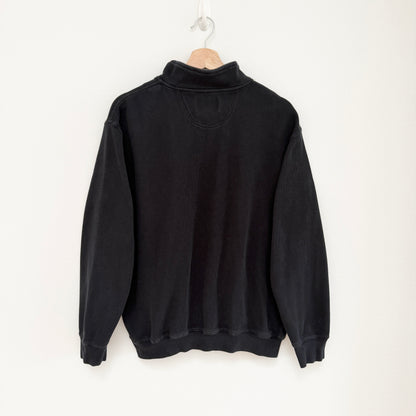 Black sweatshirt on a hanger against a white background