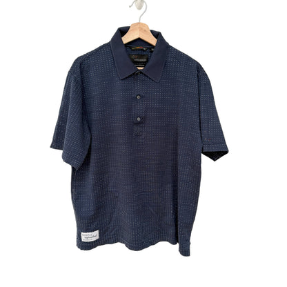 Navy blue patterned polo shirt on a hanger against a white background