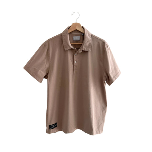 Beige polo shirt on a hanger against a white background