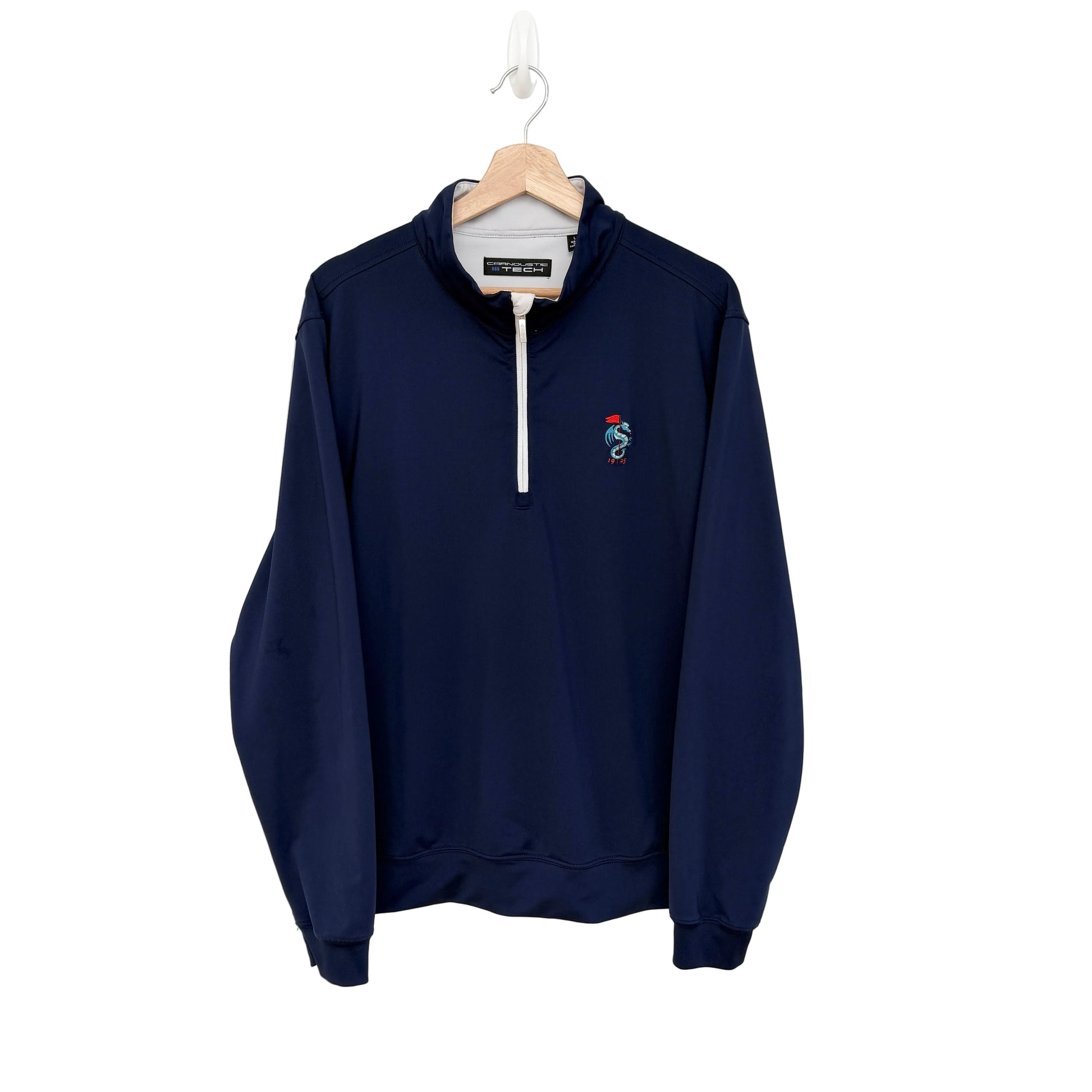A navy blue quarter-zip pullover sweatshirt hanging on a wooden hanger against a plain white wall. The sweatshirt features a small embroidered dragon logo on the left chest and a white zipper.