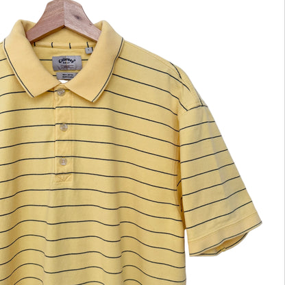 A yellow short-sleeve polo shirt with thin black horizontal stripes, hanging on a wooden hanger against a plain white wall. A small black V-neck logo is visible on the upper back.