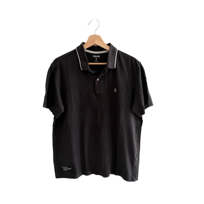 Black polo shirt on a hanger against a white background