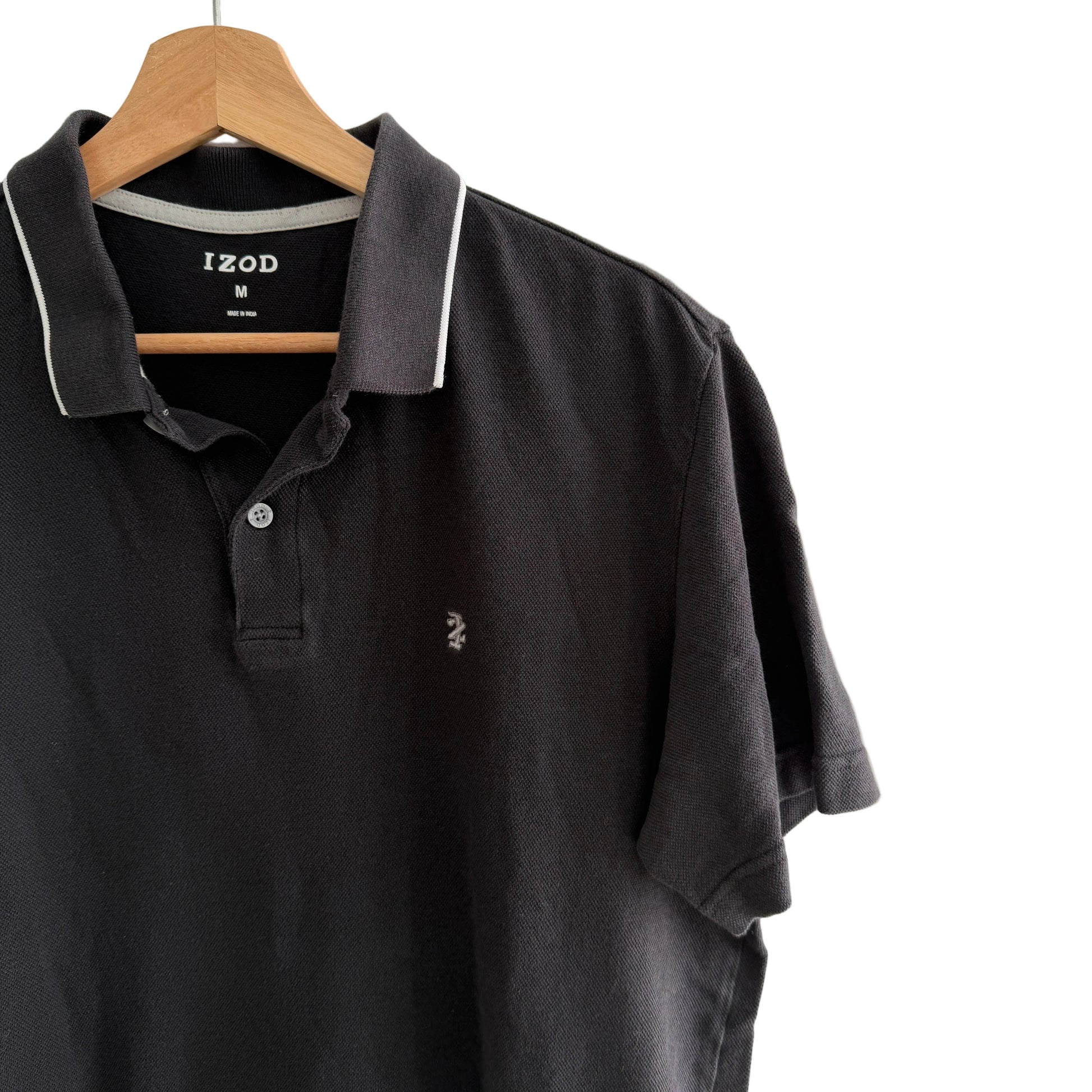 Black polo shirt on a hanger with a white background