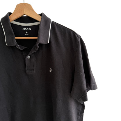 Black polo shirt on a hanger with a white background
