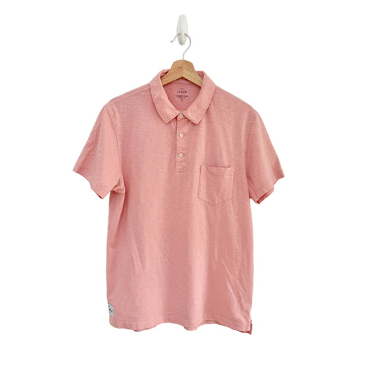Pink polo shirt on a hanger against a white background