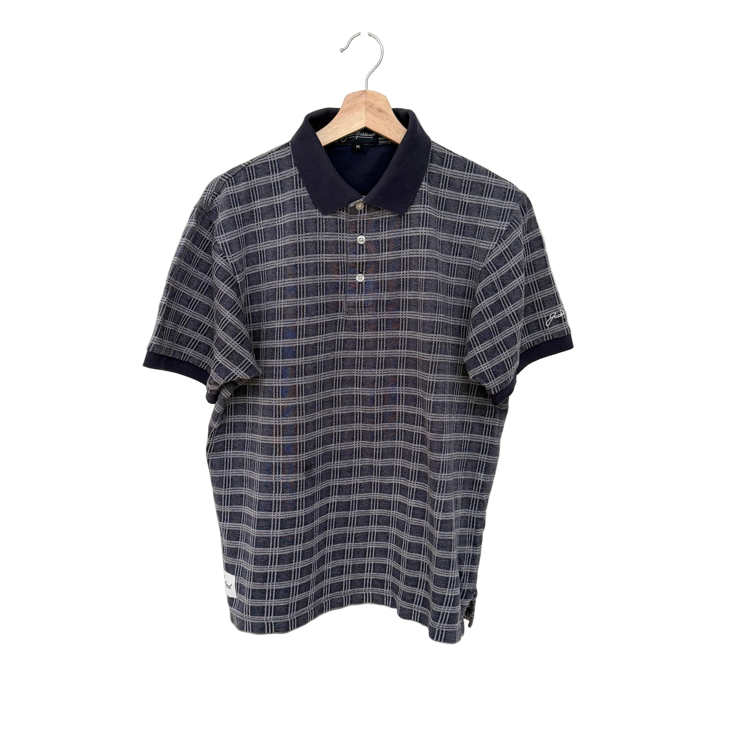 Plaid polo shirt on a hanger against a white background