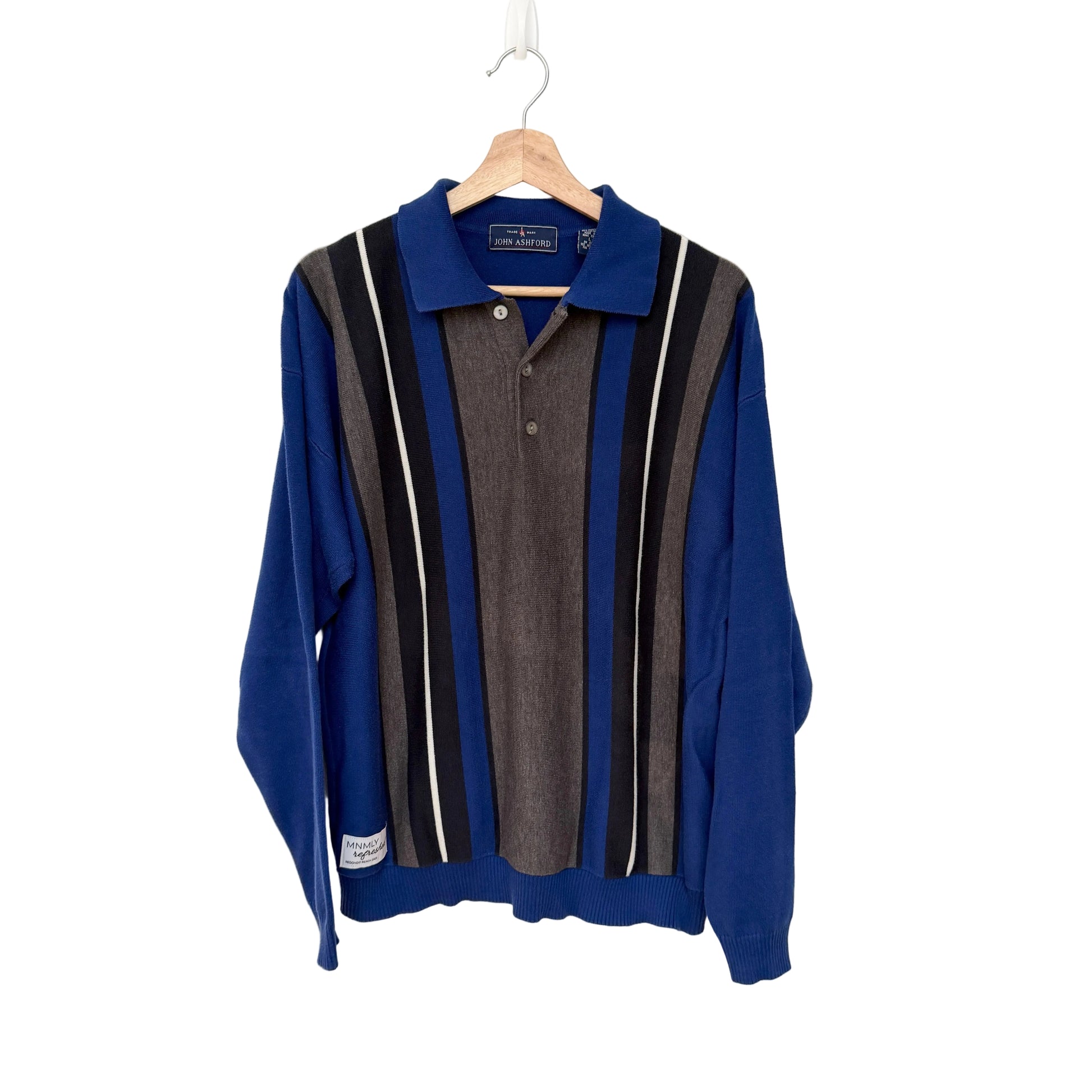 Blue sweater with striped pattern on a hanger against a white background